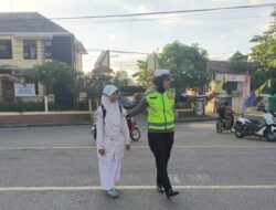Bantu Siswa Menyeberang, Polisi Ingatkan Pengendara Gunakan Helm SNI dan Lengkapi Surat Kendaraan